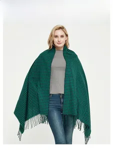 Detail of green and black plaid scarf with high-density knit and soft tassel edge