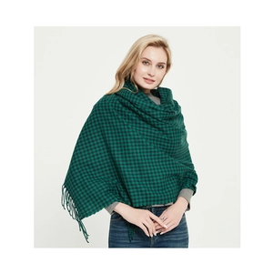 Detail of green and black plaid scarf featuring woven fabric texture and tassel trim