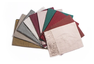 Detail shot of assorted tartan scarves featuring multiple colors and long fringe edges