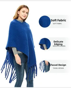Detailed view of royal blue bouclé knit poncho with soft fringes and refined hem stitching