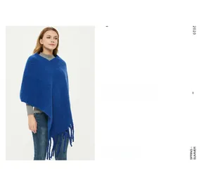 Detail of royal blue knit poncho with long tassels and fluffy mohair texture finish