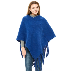 Royal blue knitted poncho with thick wool texture and long fringe tassels for winter fashion