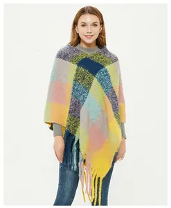 Close-up of colorful checkered knit poncho featuring fuzzy texture and long tassel fringe