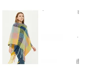 Detail view of colorful plaid poncho featuring long tassels and thick knit texture