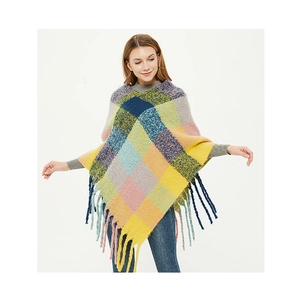 Close-up of colorful plaid knit texture and long tassel fringe details on a poncho