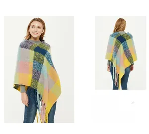 Close-up of colorful checkered poncho featuring thick tassel trim and warm knit texture
