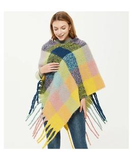Close-up of colorful checkered knit poncho featuring vibrant plaid patterns and long tassels