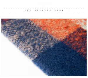 Detail of soft plaid knit shawl with blue and orange thick fleece texture and fringe