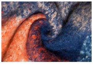 Detailed close-up of thick knit plaid shawl showing vibrant orange and blue wool textures