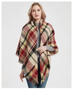 Detailed view of women's plaid scarf with red and black tartan pattern and fringe edges