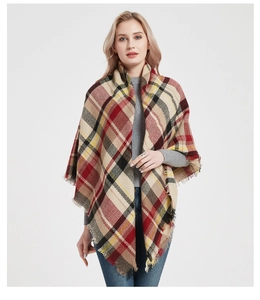 Detailed macro view of classic red and beige plaid cashmere-like scarf with fringe tassels