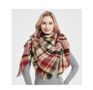 Detail of red and black plaid cashmere-feel scarf with fringe edges worn as a shawl
