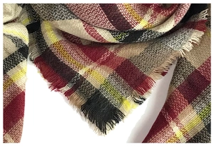 Detail shot of soft cashmere-feel fabric with a classic red and black plaid pattern