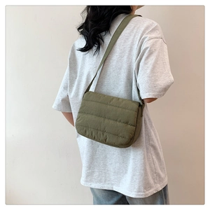 Detailed view of army green quilted crossbody bag with stylish padded texture and wide strap