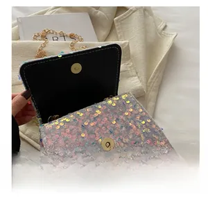 Detail shot of the golden magnetic buckle and sparkling sequins on the chain bag