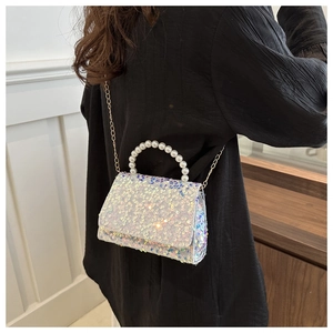 Sparkly white sequin handbag with pearl handle and metal chain shown on model back