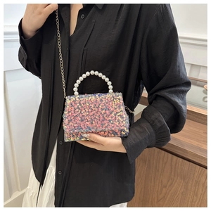 Detail of colorful sequin mini bag featuring imitation pearl handle and golden chain strap