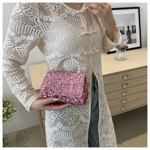 Close-up of pink sequin handbag featuring a pearl handle and gold chain strap