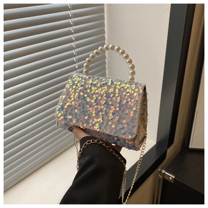 Close-up of sparkling sequin crossbody bag with elegant pearl handle and metal chain