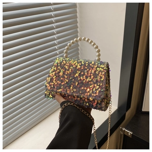 Close-up of colorful iridescent sequins and faux pearl handle on a small square handbag