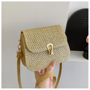 Detail of woven straw texture and gold U-shaped metal buckle on the crossbody bag