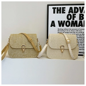 Detail of woven straw tote bags with metallic drop buckles and adjustable leather straps