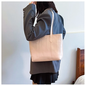 Détail du cabas rose en cuir gaufré verticalement avec des finitions de couture fines