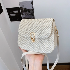 Minimalist beige woven crossbody bag with elegant golden horseshoe buckle closure