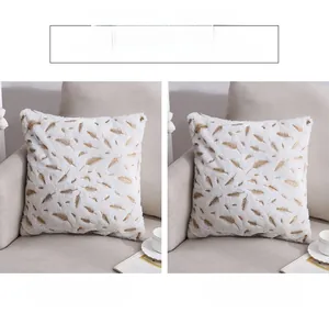 Detail of white PV velvet pillowcase with gold feather print on cozy beige sofa