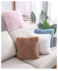 Close-up of soft plush decorative cushions in pastel colors on a modern grey sofa