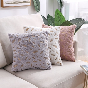Plush pillow covers with gold feather patterns in grey, cream, and dusty rose colors