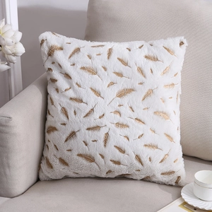 Plush square pillow cover with gold feather pattern on sofa with coffee cup