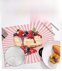 Detail of waterproof linen placemat featuring a strawberry cake pattern and water droplets
