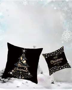Detail of black gold Christmas pillow covers with festive golden prints on soft peach skin fabric