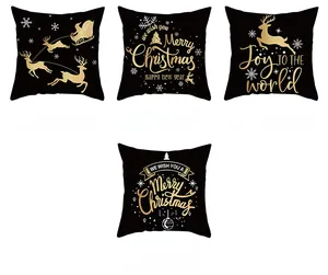 Detail of four black and gold Christmas pillow covers with reindeer and tree patterns