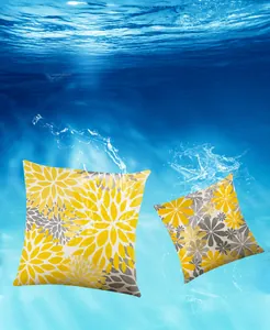 Close-up of waterproof fabric showing water droplets on yellow and grey floral pillow covers