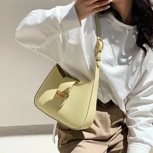 Fashionable creamy yellow leather baguette shoulder bag with golden metallic buckle