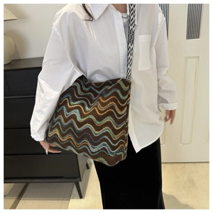 Dettaglio borsa tote in maglia con motivi a onde e tracolla a scacchi neri e bianchi