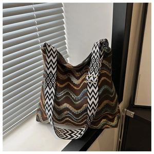 Chic knit wavy patterned crossbody tote bag with a jacquard strap on a window sill
