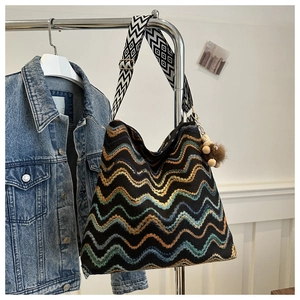 Dettaglio della borsa tote bohémien in maglia con motivi a onde e tracolla geometrica