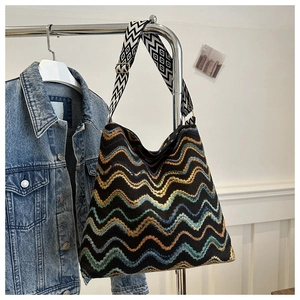Detail of bohemian weave tote bag with colorful wave patterns and a geometric strap