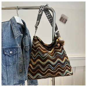 Detail of bohemian knit tote bag with colorful waves and geometric woven strap