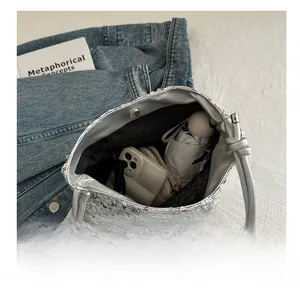 Geräumiges Innere der silbernen Pailletten-Abendtasche mit Handy und Regenschirm