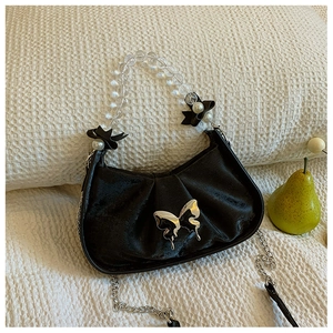 Détail du sac plissé noir en croissant avec papillon argenté et poignée en perles