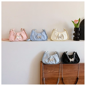 Detailed view of pleated small square bags featuring pearl handles and butterfly buckles
