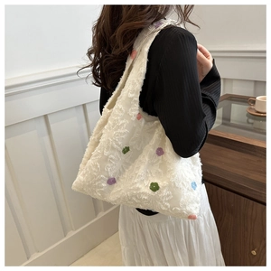 Detail view of floral embroidered texture and soft fabric on large nylon shoulder bag