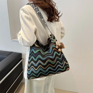 Chic knit tote bag with zigzag patterns, wide shoulder strap and plush lion charm