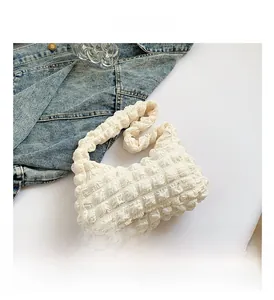 Détail d'un sac à main blanc avec texture à bulles et design matelassé élégant