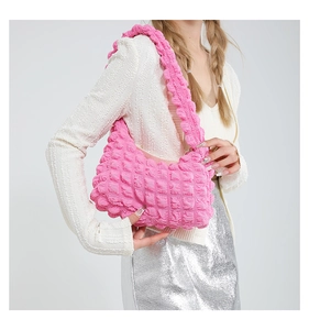 Détail du sac à bandoulière rose fuchsia à texture bulles montrant le motif 3D du tissu