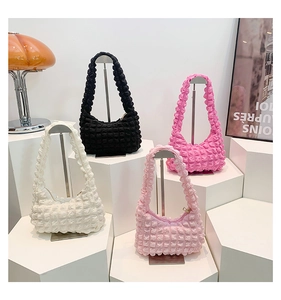 Détail de sacs à bandoulière texturés à bulles colorées sur des supports de boutique